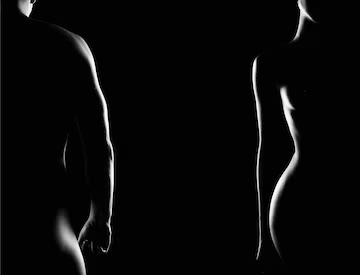 Silhouettes of two nude figures, one male and one female, are partially illuminated from the side against a black background, evoking the serene atmosphere of a private masseur session.